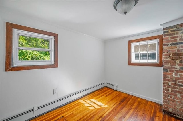 unfurnished room with baseboard heating, crown molding, and hardwood / wood-style flooring