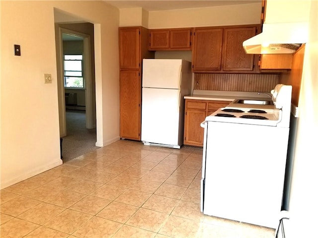 kitchen with sink, range hood, a baseboard heating unit, white appliances, and light tile patterned floors