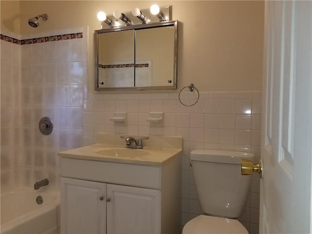 full bathroom with washtub / shower combination, vanity, toilet, and tile walls