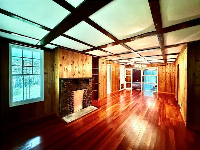 living room featuring coffered ceiling, wooden walls, beam ceiling, hardwood / wood-style flooring, and a fireplace