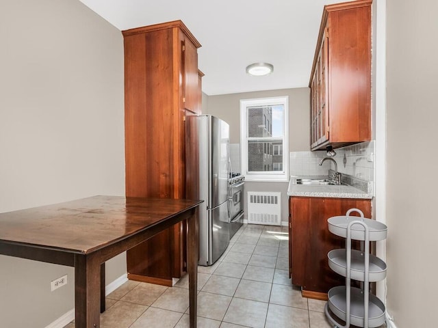 3065 Sedgwick Ave Unit 3A, Bronx, NY 10468 - kitchen featuring appliances with stainless steel finishes, radiator heating unit, a sink, decorative backsplash, and brown cabinetry