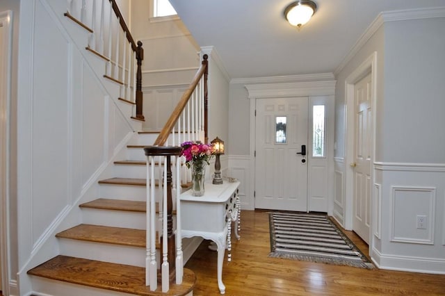 entrance foyer with crown molding, a healthy amount of sunlight, and light hardwood / wood-style floors