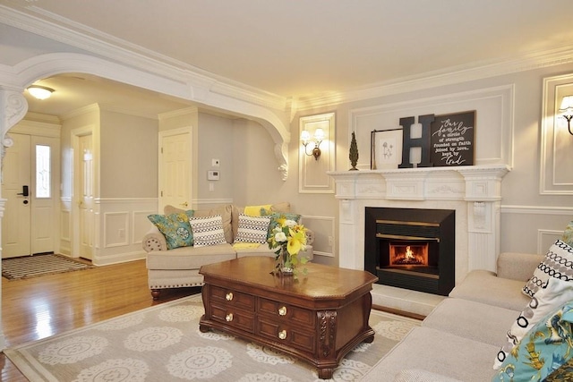 living room with light wood-type flooring and ornamental molding