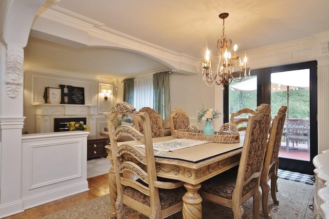 dining area featuring a chandelier, wood-type flooring, and ornamental molding