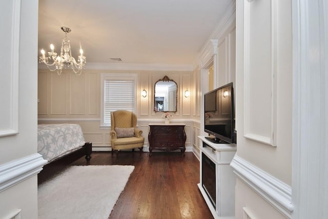 bedroom with dark hardwood / wood-style floors, a baseboard heating unit, crown molding, and an inviting chandelier