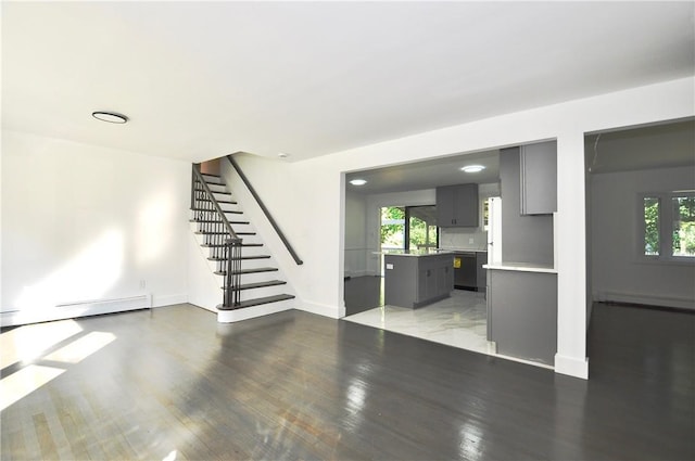 unfurnished living room with light hardwood / wood-style floors, a baseboard radiator, and a wealth of natural light