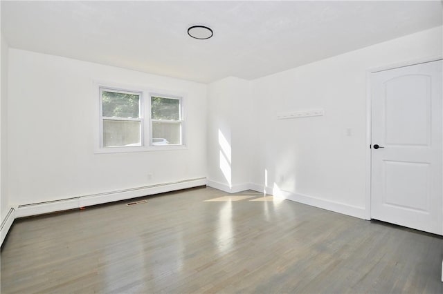 spare room with hardwood / wood-style flooring and a baseboard heating unit