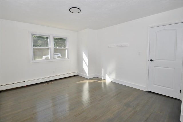 spare room featuring a baseboard radiator and dark hardwood / wood-style floors