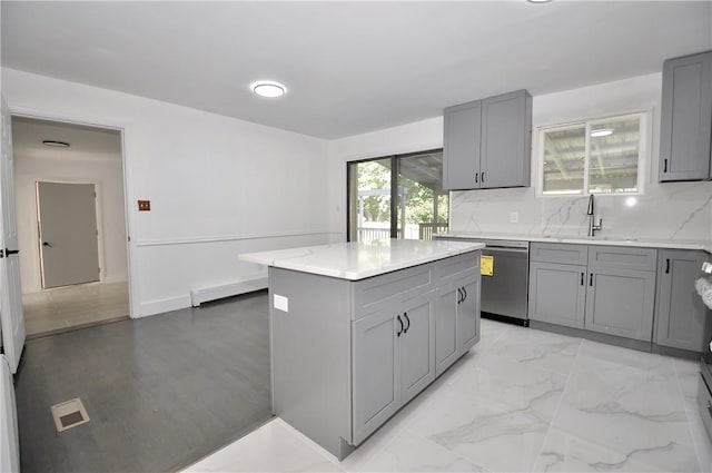 kitchen featuring gray cabinetry, dishwasher, sink, and a kitchen island