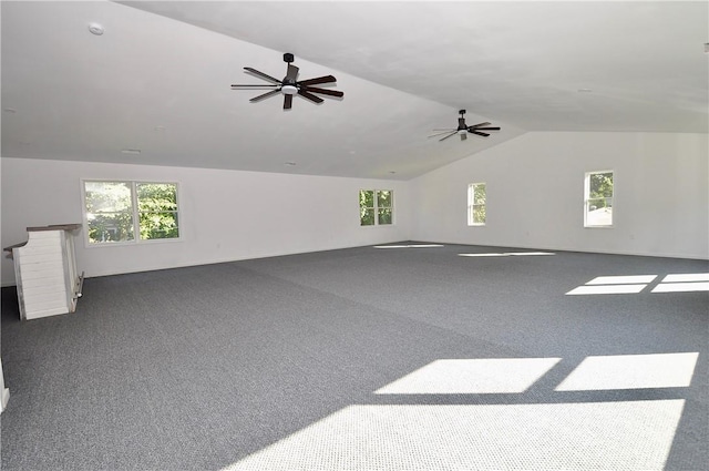 interior space featuring ceiling fan, dark carpet, a wealth of natural light, and vaulted ceiling