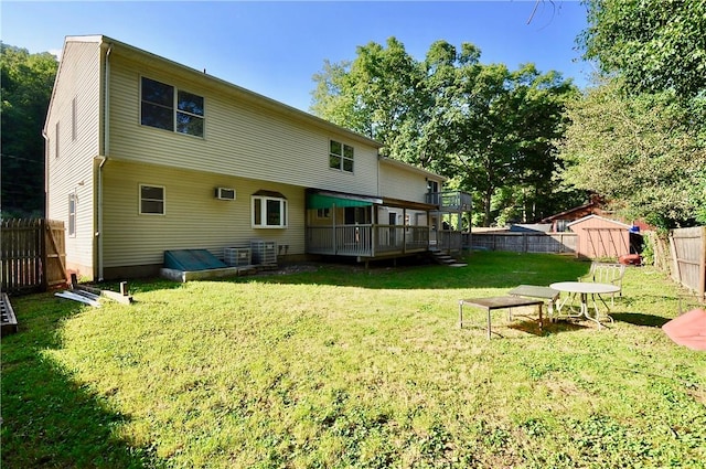 back of house featuring a lawn, a shed, and a deck