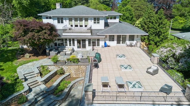 back of house with a patio area, an outdoor living space, and a balcony