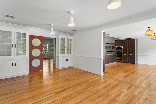 interior space with light wood-type flooring, a baseboard radiator, and ornamental molding