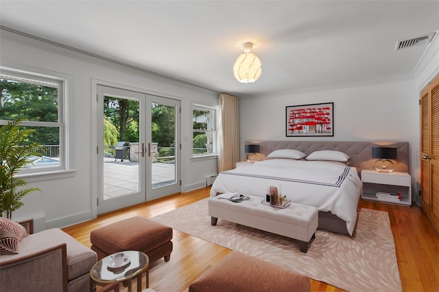 bedroom with access to outside, french doors, light wood finished floors, and visible vents