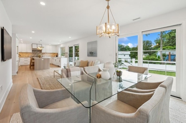 dining area featuring light hardwood / wood-style floors and a chandelier