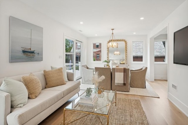 living room with a notable chandelier and light hardwood / wood-style flooring