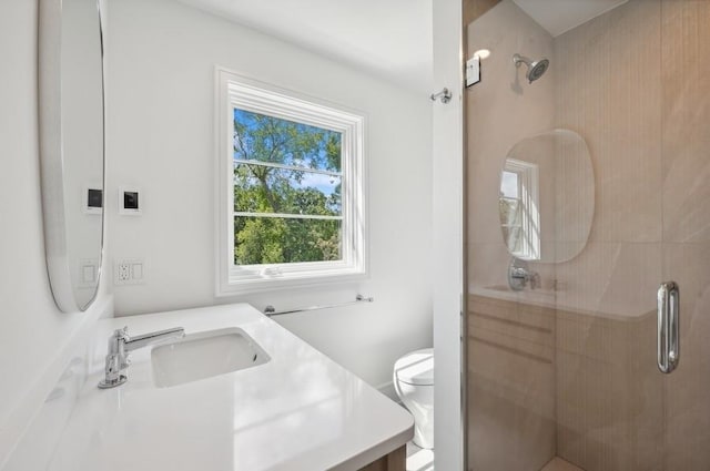 bathroom featuring toilet, walk in shower, and vanity