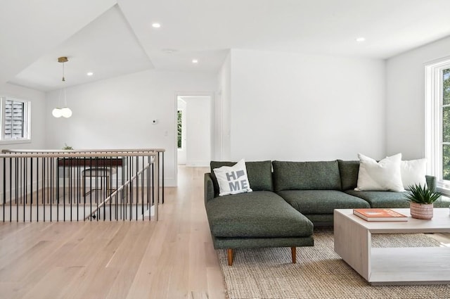 living room featuring light wood-type flooring and vaulted ceiling