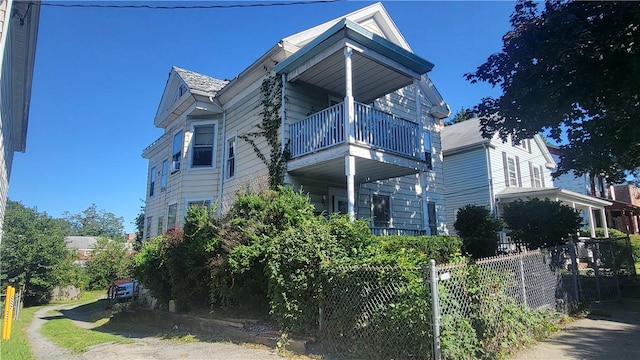 view of side of home with a balcony and fence