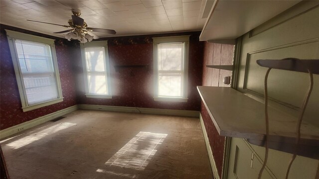 unfurnished dining area with visible vents, ceiling fan, and baseboards