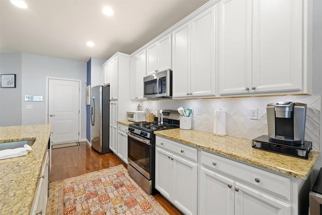 kitchen with white cabinetry, stainless steel appliances, and dark wood-type flooring