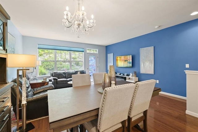 dining room with dark hardwood / wood-style floors and an inviting chandelier