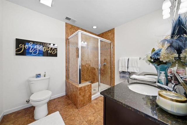 bathroom featuring vanity, toilet, and a shower with door