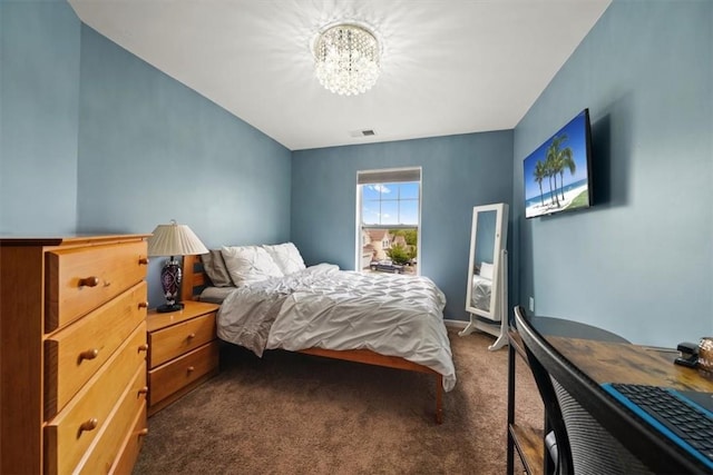 bedroom with dark carpet and a notable chandelier