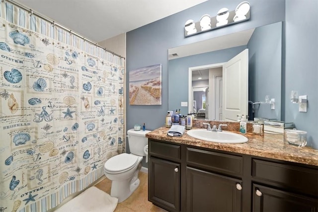 bathroom with tile patterned flooring, vanity, and toilet