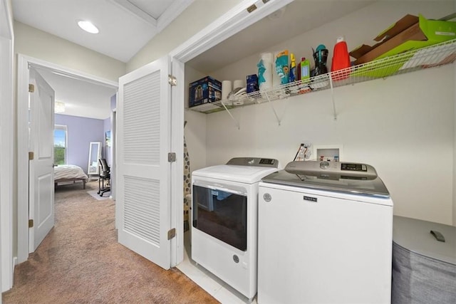 clothes washing area with independent washer and dryer and light colored carpet