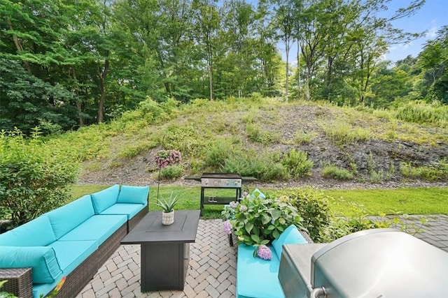 view of patio with area for grilling and an outdoor living space with a fire pit