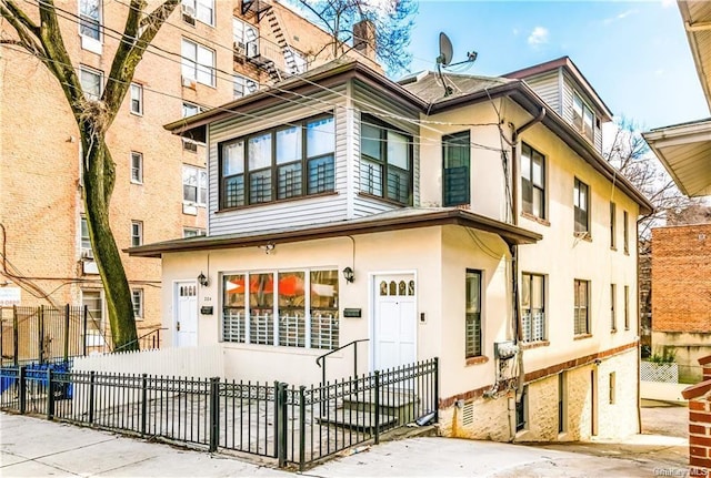 204 W 260th St, Bronx, NY 10471 - view of front facade featuring a fenced front yard and stucco siding