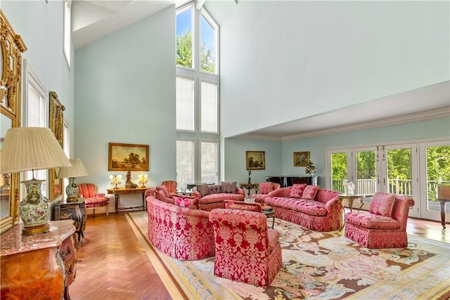 living room featuring plenty of natural light, a towering ceiling, crown molding, and light parquet floors