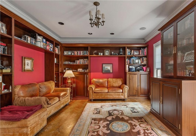 living area featuring a chandelier, built in shelves, light hardwood / wood-style floors, and crown molding