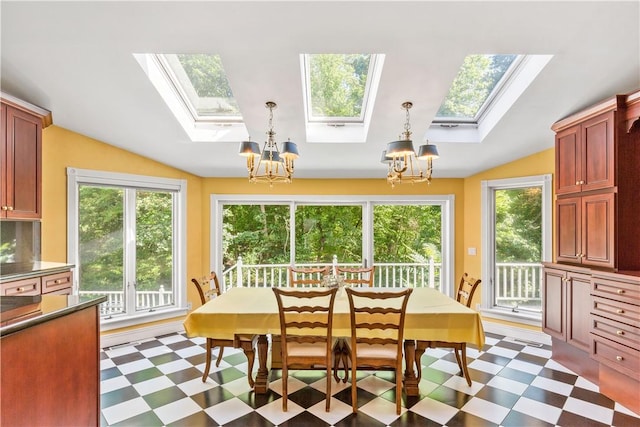 dining space featuring vaulted ceiling with skylight and a chandelier