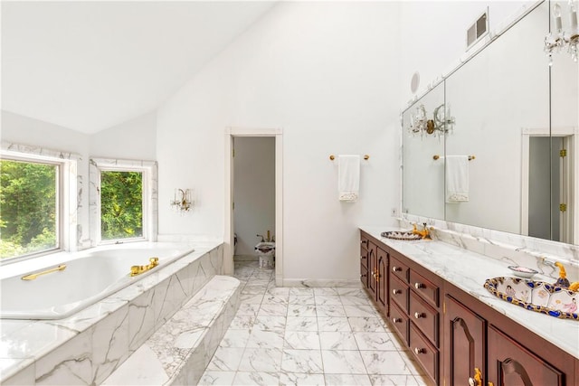 bathroom featuring tiled bath, vanity, and high vaulted ceiling