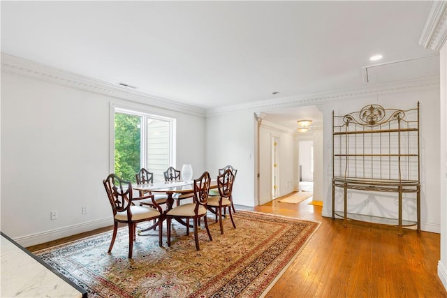 dining area featuring crown molding and hardwood / wood-style floors