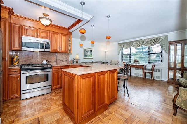 kitchen with appliances with stainless steel finishes, backsplash, light stone counters, light parquet floors, and decorative light fixtures