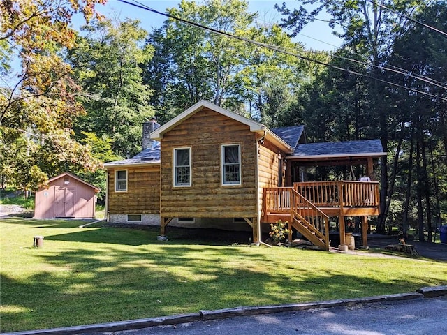 back of house with a lawn, a storage shed, and a wooden deck