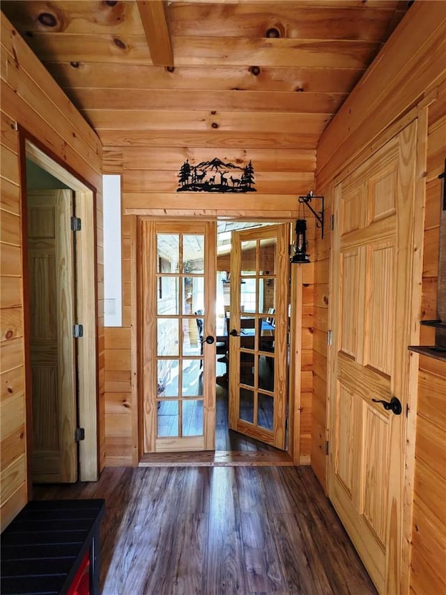 doorway with french doors, dark hardwood / wood-style flooring, wooden ceiling, and wood walls