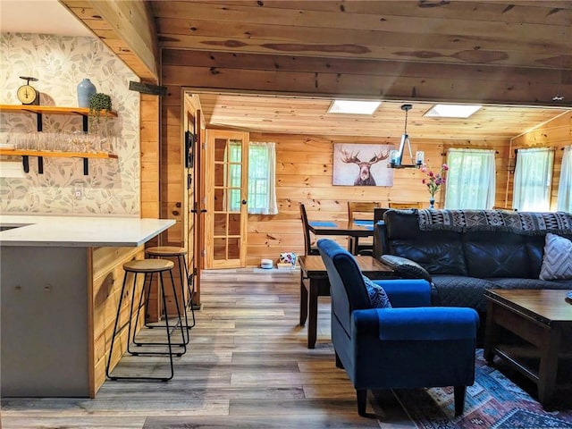 living room with a skylight, wood walls, dark hardwood / wood-style flooring, and wood ceiling