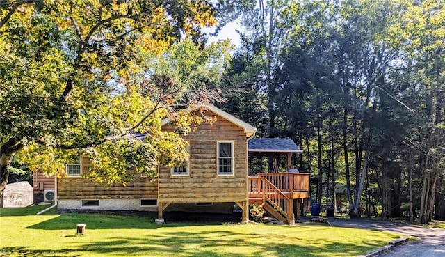 rear view of property with a lawn and a wooden deck