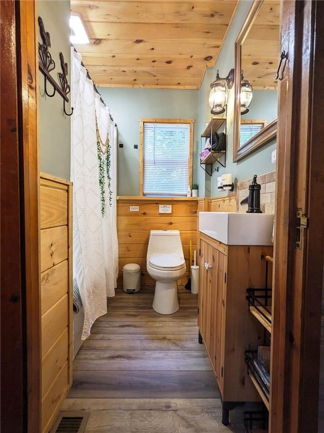 bathroom with wood walls, toilet, wood-type flooring, and wood ceiling