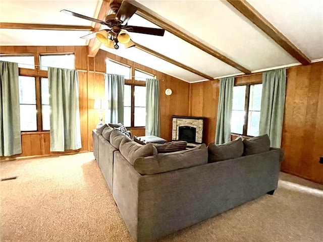 living room with a fireplace, lofted ceiling with beams, a wealth of natural light, and wood walls