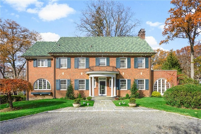 colonial home featuring a front lawn