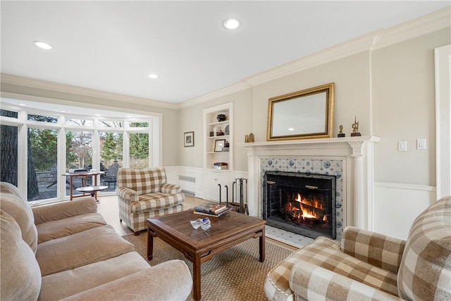 living room with a fireplace, built in shelves, radiator, and ornamental molding