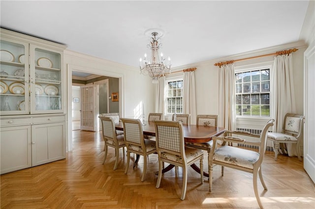 dining space with light parquet flooring, crown molding, and a notable chandelier