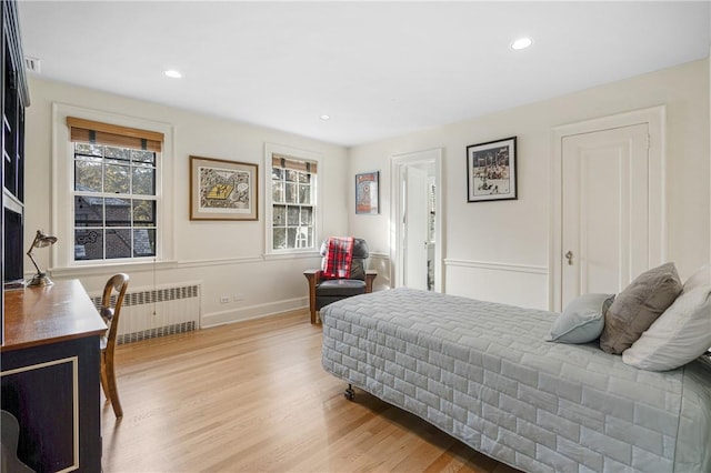 bedroom with light hardwood / wood-style flooring and radiator