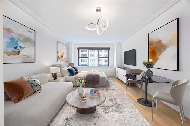 living room with crown molding, light hardwood / wood-style floors, and an inviting chandelier