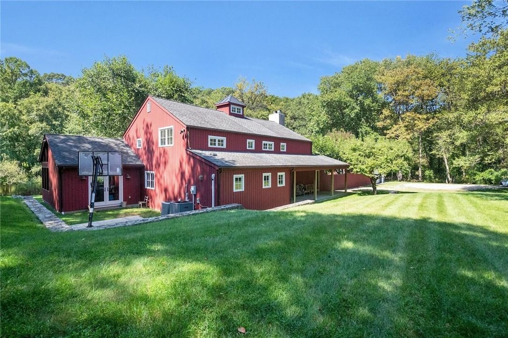 rear view of property featuring an outbuilding and a yard